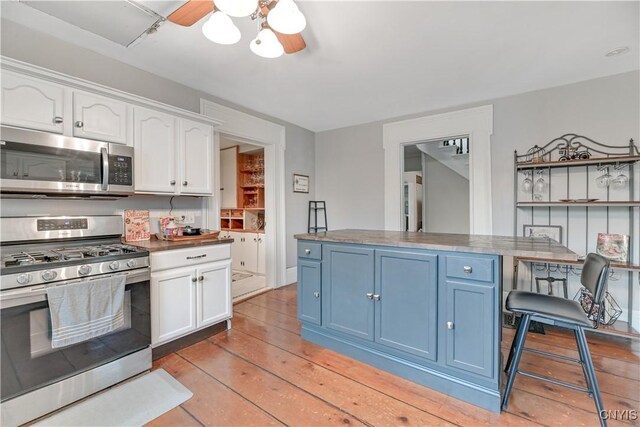 6188 Lake St, Aurelius, NY 13034 - kitchen featuring appliances with stainless steel finishes, white cabinetry, blue cabinets, ceiling fan, and light wood-style floors