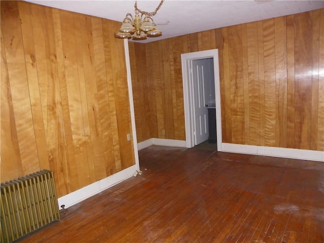 202-204-206 N Monroe St, Reading, NY 14891 - empty room with radiator, a chandelier, wood walls, and wood-type flooring