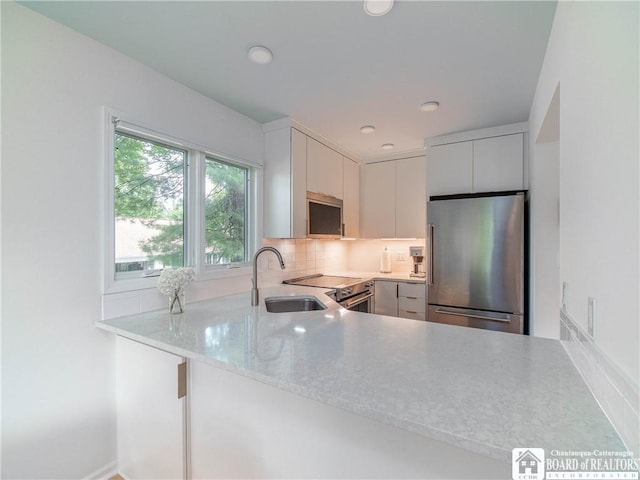 29 Elm Ln Unit 24, Chautauqua, NY 14722 - kitchen with stainless steel appliances, decorative backsplash, a peninsula, recessed lighting, and light stone counters