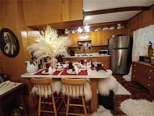 41 N Franklin St, New Albion, NY 14719 - kitchen with appliances with stainless steel finishes, light countertops, wood walls, beamed ceiling, and brown cabinets