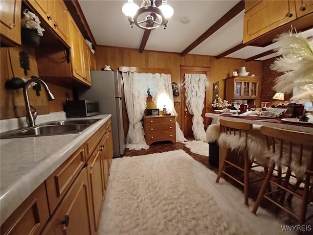 41 N Franklin St, New Albion, NY 14719 - kitchen with beamed ceiling, a chandelier, light countertops, brown cabinets, and wooden walls