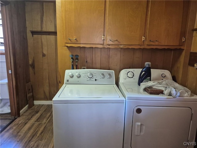 313 W 3rd St S, Fulton, NY 13069 - laundry room with separate washer and dryer, dark wood-style floors, cabinet space, and wood walls