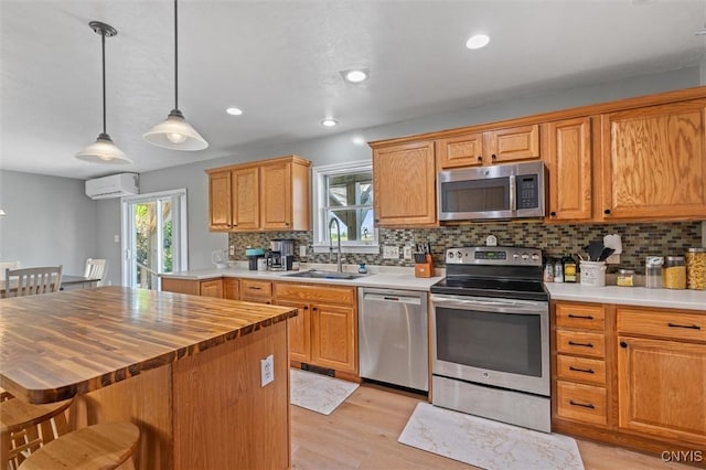 13489 Case Rd, Lyme, NY 13622 - kitchen with appliances with stainless steel finishes, butcher block countertops, tasteful backsplash, light wood-style flooring, and decorative light fixtures