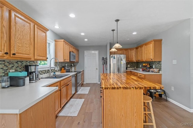 13489 Case Rd, Lyme, NY 13622 - kitchen with stainless steel appliances, butcher block counters, a center island, light wood finished floors, and decorative backsplash