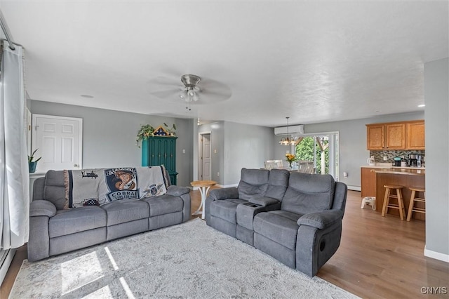 13489 Case Rd, Lyme, NY 13622 - living room with wood finished floors, a chandelier, a ceiling fan, and a baseboard radiator