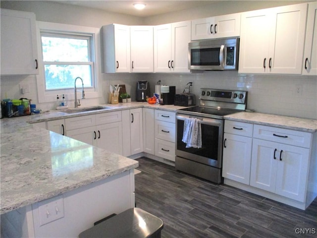 7739 Roberts St, Lenox, NY 13032 - kitchen with appliances with stainless steel finishes, white cabinetry, backsplash, and dark wood-style flooring