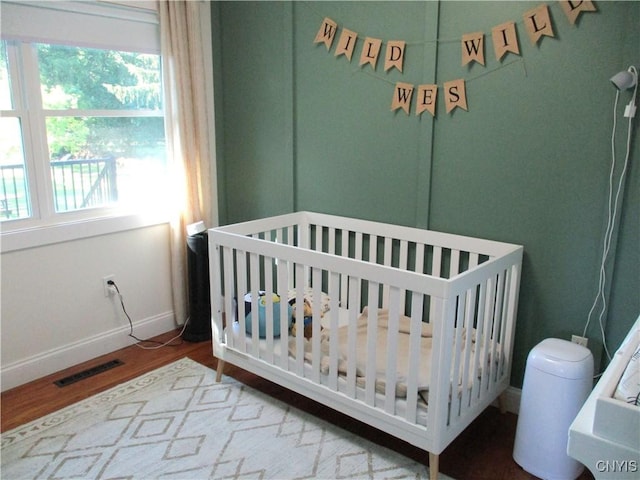 7739 Roberts St, Lenox, NY 13032 - bedroom featuring wood finished floors and a crib