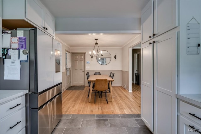 266 Chestnut St, Watertown City, NY 13601 - dining area featuring crown molding, tile patterned flooring, a chandelier, and a wainscoted wall