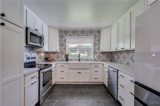 266 Chestnut St, Watertown City, NY 13601 - kitchen with stainless steel appliances, tasteful backsplash, white cabinetry, and dark tile patterned flooring