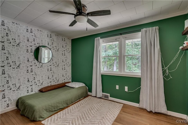 266 Chestnut St, Watertown City, NY 13601 - bedroom featuring wood finished floors, crown molding, a ceiling fan, and an accent wall