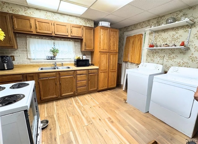 176-178 E Clark St, German Flatts, NY 13357 - kitchen with wallpapered walls, black microwave, white electric stove, and brown cabinets
