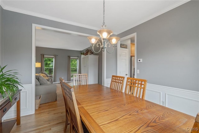 8879 Kilkenny Dr, Lysander, NY 13027 - dining area with a chandelier, light wood finished floors, ornamental molding, a wainscoted wall, and a decorative wall