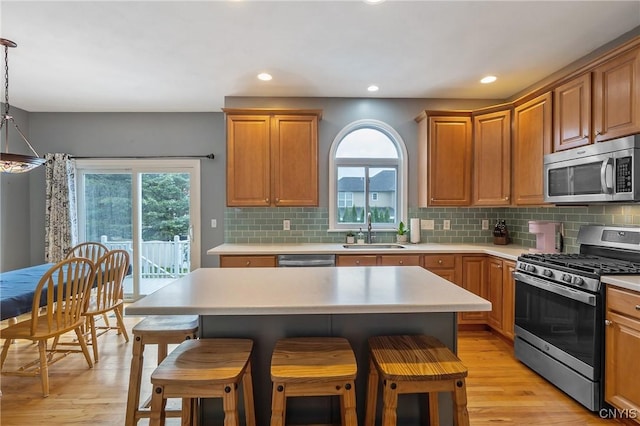 8879 Kilkenny Dr, Lysander, NY 13027 - kitchen with appliances with stainless steel finishes, a kitchen breakfast bar, light countertops, light wood finished floors, and recessed lighting
