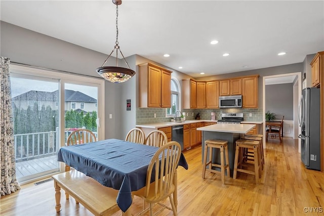 8879 Kilkenny Dr, Lysander, NY 13027 - kitchen with appliances with stainless steel finishes, a kitchen island, light countertops, decorative backsplash, and recessed lighting