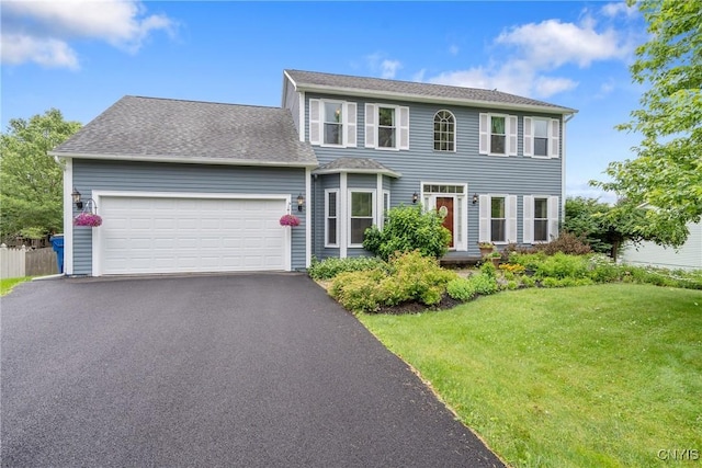 8879 Kilkenny Dr, Lysander, NY 13027 - colonial inspired home featuring a garage, a front yard, driveway, and a shingled roof