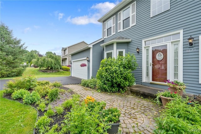 8879 Kilkenny Dr, Lysander, NY 13027 - view of exterior entry with asphalt driveway and a garage
