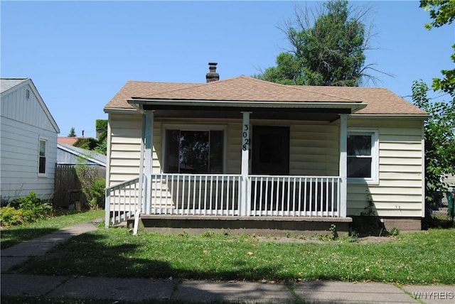 3028 Welch Ave, Niagara Falls, NY 14303 - bungalow featuring covered porch, a shingled roof, and a chimney