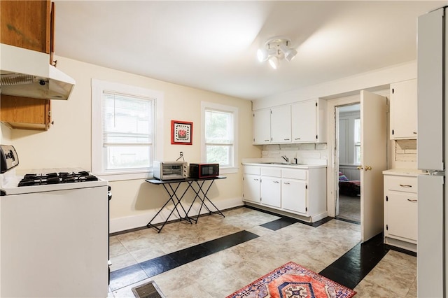 72 Weld St, Rochester, NY 14605 - kitchen with white gas range, white cabinetry, light countertops, under cabinet range hood, and black microwave