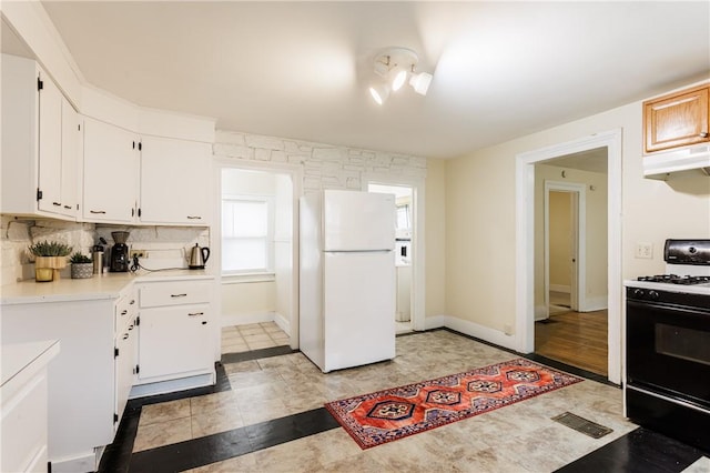 72 Weld St, Rochester, NY 14605 - kitchen featuring freestanding refrigerator, gas range oven, light countertops, white cabinetry, and backsplash