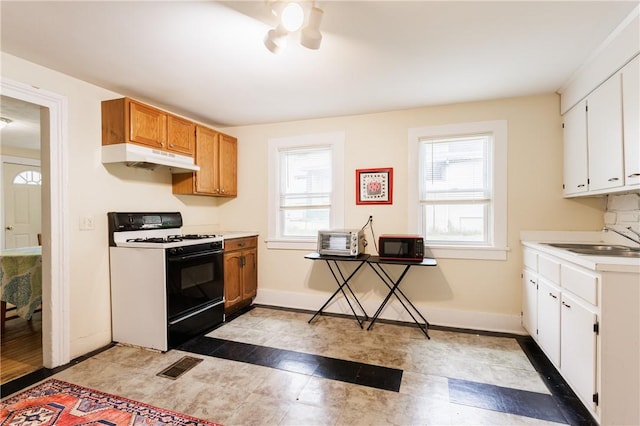 72 Weld St, Rochester, NY 14605 - kitchen featuring gas range oven, under cabinet range hood, healthy amount of natural light, and light countertops