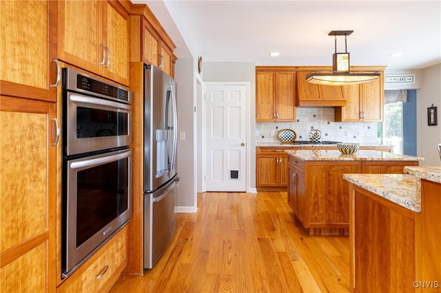 2516 W Lake Rd, Skaneateles, NY 13152 - kitchen featuring appliances with stainless steel finishes, brown cabinetry, light wood-style floors, a kitchen island, and backsplash