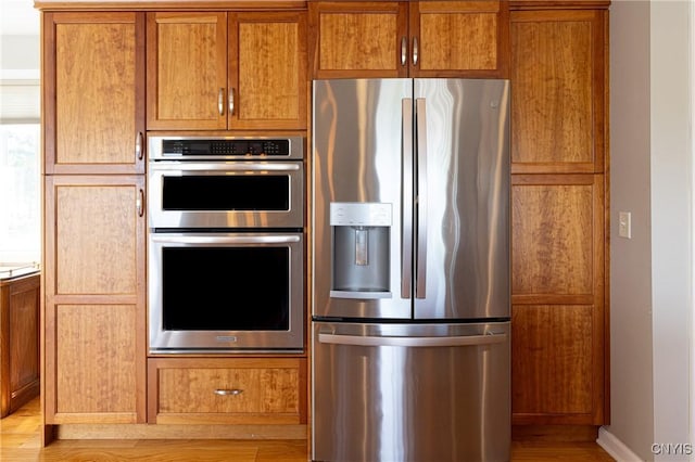 2516 W Lake Rd, Skaneateles, NY 13152 - kitchen featuring appliances with stainless steel finishes, light wood-style flooring, brown cabinets, and light countertops