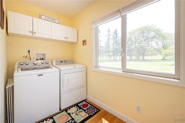 2516 W Lake Rd, Skaneateles, NY 13152 - washroom featuring cabinet space, washer and dryer, healthy amount of natural light, and light wood finished floors