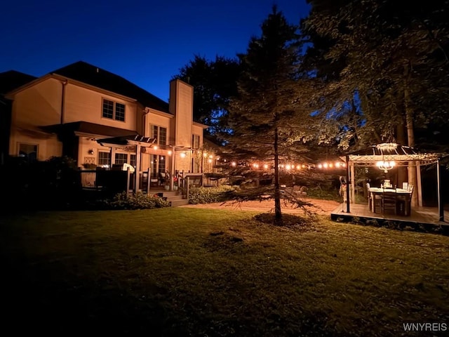 1469 Hopkins Rd, Amherst, NY 14221 - yard at twilight featuring a gazebo, a pergola, a wooden deck, and a lawn