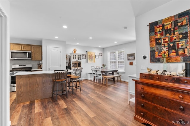 720 N Star Rd, Elma, NY 14052 - kitchen featuring appliances with stainless steel finishes, wood finished floors, a breakfast bar area, decorative backsplash, and recessed lighting