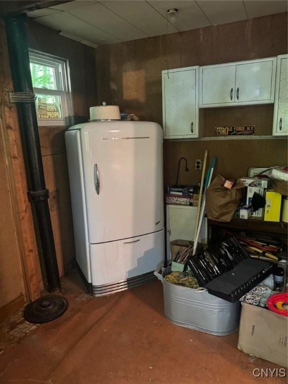 182 Seneca Rd, Webb, NY 13420 - kitchen with fridge, water heater, and white cabinetry