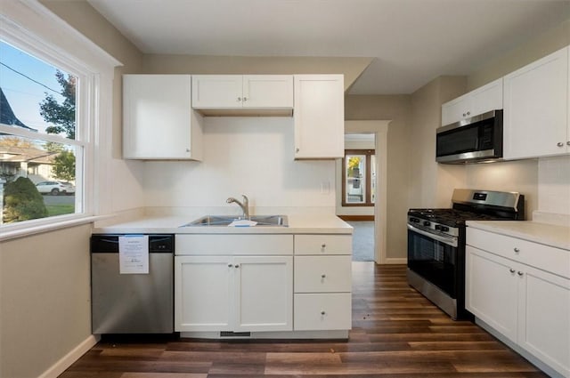 23 Peacock St, Auburn, NY 13021 - kitchen with appliances with stainless steel finishes, healthy amount of natural light, dark wood-style floors, and white cabinets