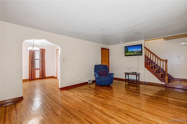 2104 Walnut Ave, Niagara Falls, NY 14301 - unfurnished room with arched walkways, light wood finished floors, stairs, and a chandelier
