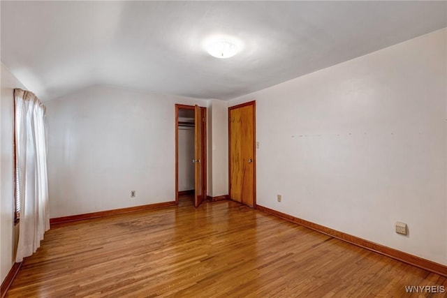 2104 Walnut Ave, Niagara Falls, NY 14301 - unfurnished bedroom with light wood-style floors, lofted ceiling, and a closet