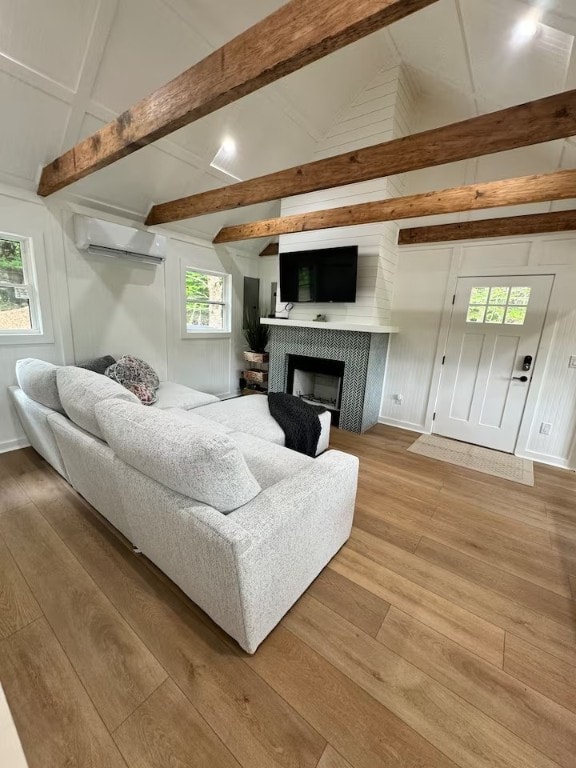 1737 Tupper Hill Rd, Franklin, NY 13775 - living room with a wall unit AC, wood finished floors, a fireplace, and healthy amount of natural light
