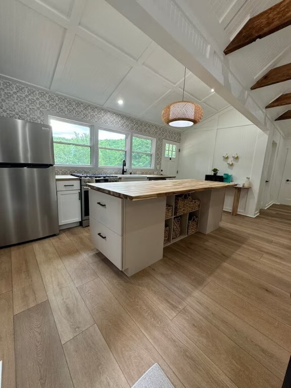 1737 Tupper Hill Rd, Franklin, NY 13775 - kitchen with stainless steel appliances, butcher block countertops, light wood-style flooring, a center island, and beamed ceiling