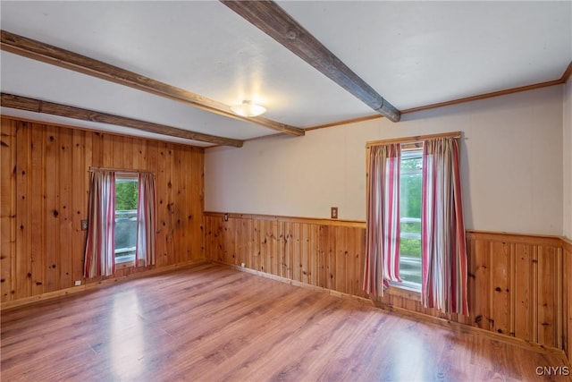 388 Sutton Rd, Schroeppel, NY 13132 - unfurnished room with beam ceiling, plenty of natural light, wood finished floors, wood walls, and a wainscoted wall
