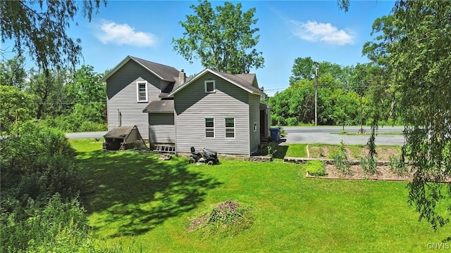 388 Sutton Rd, Schroeppel, NY 13132 - rear view of house with a lawn, a chimney, and roof with shingles