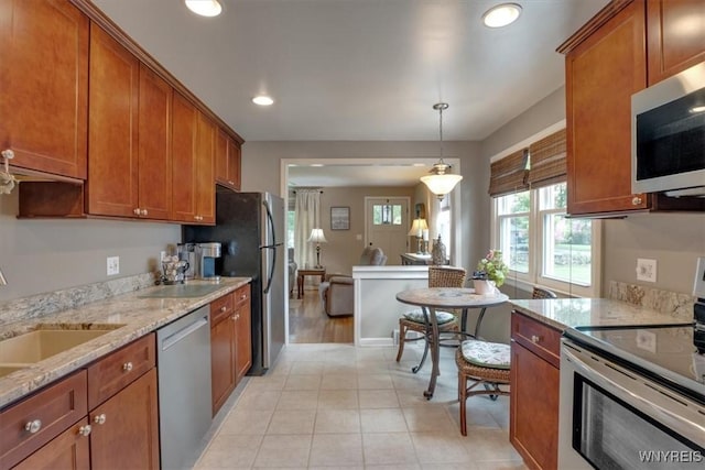 150 Lorfield Dr, Amherst, NY 14226 - kitchen with stainless steel appliances, brown cabinets, light stone countertops, hanging light fixtures, and recessed lighting