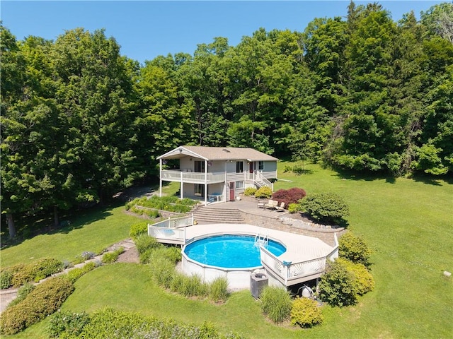 5343 Cedarwood Ln, Conesus, NY 14435 - rear view of property with a wooden deck, stairway, a lawn, an outdoor pool, and a forest view