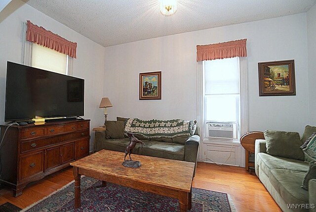 57 Christiana St, North Tonawanda, NY 14120 - living room with light wood-style floors, cooling unit, and a textured ceiling