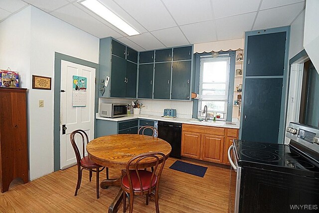 57 Christiana St, North Tonawanda, NY 14120 - kitchen with stainless steel appliances, light wood finished floors, light countertops, and a paneled ceiling