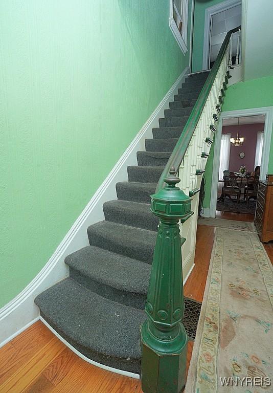 57 Christiana St, North Tonawanda, NY 14120 - stairway featuring wood finished floors and a chandelier