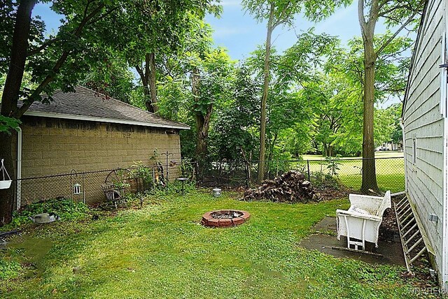 57 Christiana St, North Tonawanda, NY 14120 - fenced backyard featuring a fire pit