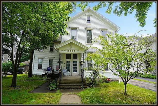 57 Christiana St, North Tonawanda, NY 14120 - view of front facade featuring french doors, a porch, and a front lawn