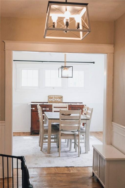 459 W Water St, Elmira City, NY 14905 - dining space with a chandelier, wood finished floors, wainscoting, and a decorative wall