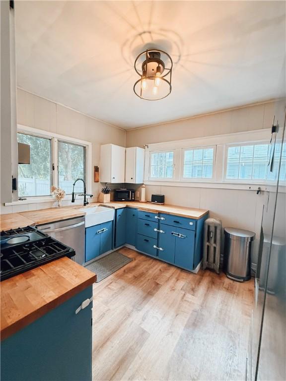 459 W Water St, Elmira City, NY 14905 - kitchen with blue cabinets, butcher block countertops, light wood-type flooring, and black microwave
