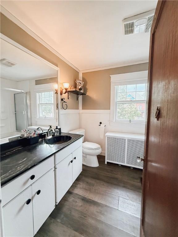 459 W Water St, Elmira City, NY 14905 - full bath with radiator heating unit, vanity, wood finished floors, a wainscoted wall, and a shower with shower door