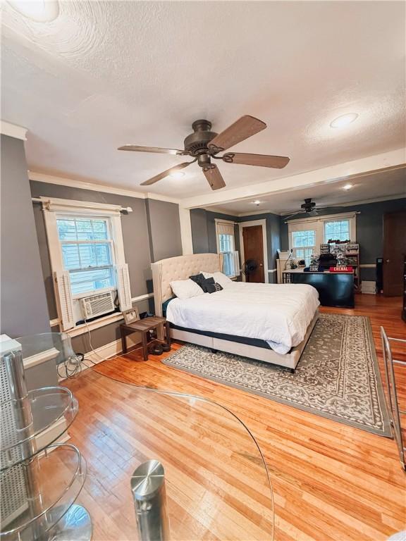 459 W Water St, Elmira City, NY 14905 - bedroom with wood finished floors, cooling unit, multiple windows, a textured ceiling, and ornamental molding