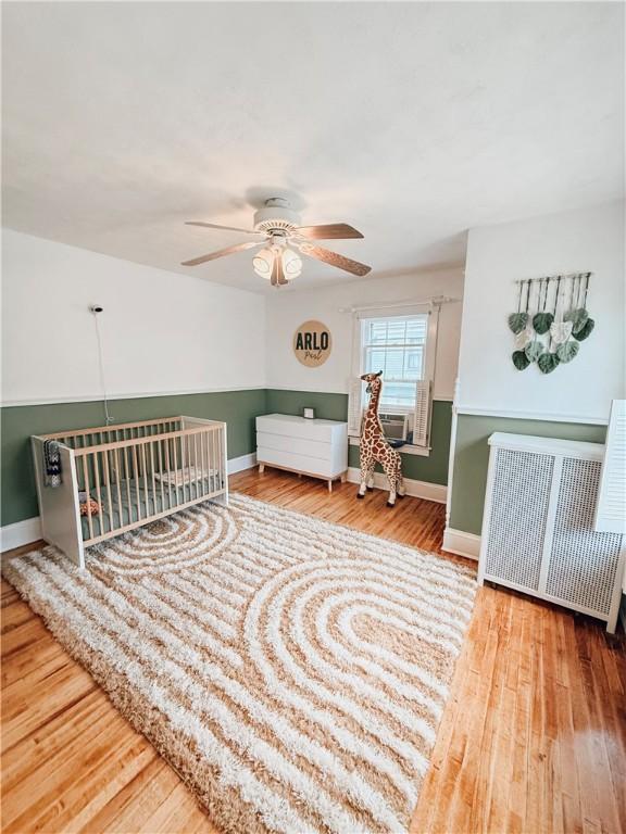 459 W Water St, Elmira City, NY 14905 - sitting room featuring radiator heating unit, wood finished floors, and ceiling fan