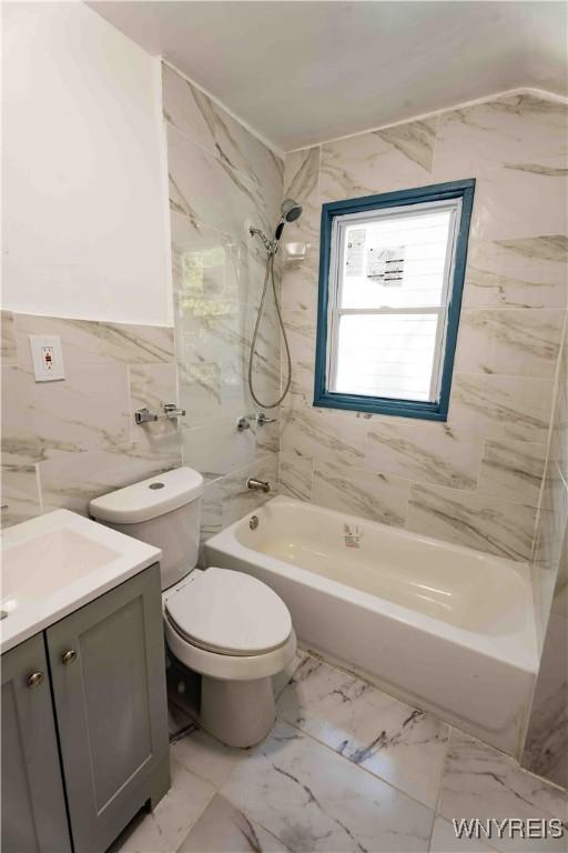 807 Tifft St, Buffalo, NY 14220 - bathroom featuring vanity, shower / bath combination, tile walls, and marble look tile flooring